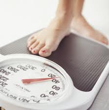 woman stepping on weight scales